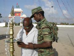 Matryr Vaiko's father Sivam lights the oil lamp at the Elephantpass memorial site in early morning on Martyr's day.jpg