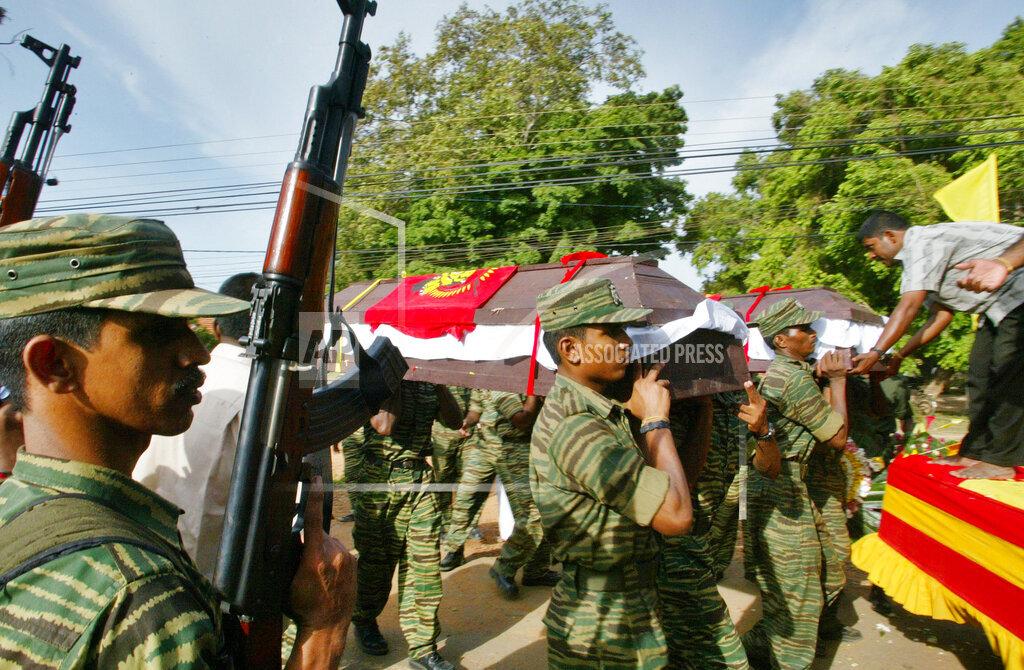 Tamil Tiger fighters carry the remains of Arumugam Anandakumar and Sangeethan for burial in Kilinochchi..jpg