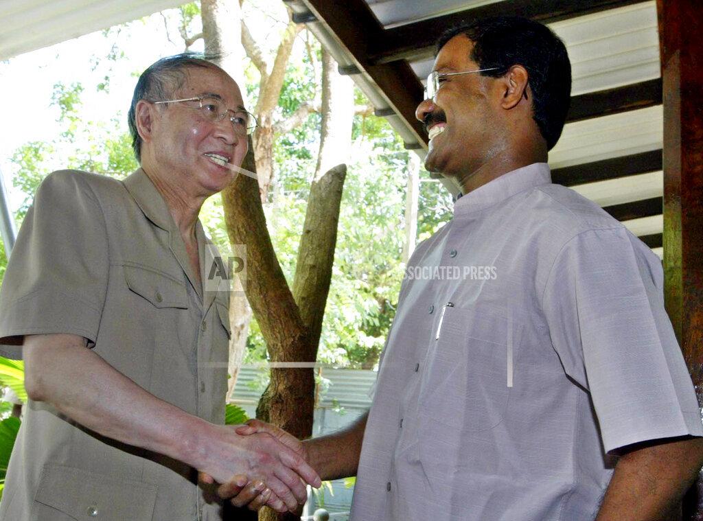 Japanese special peace envoy Yasushi Akashi, left, arrives for talks with S.P. Thamilselvan, right, head of the political wing of Tamil Tigers, prior to their meeting in Tiger controlled town.jpg
