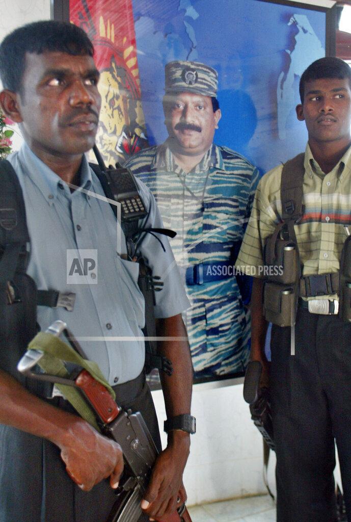 Tamil Tiger rebels stand guard near the pictures of leader Velupillai Prabhakaran, at Kokkadichcholai, a rebel-held region of Batticaloa feb 3, 2006.jpg