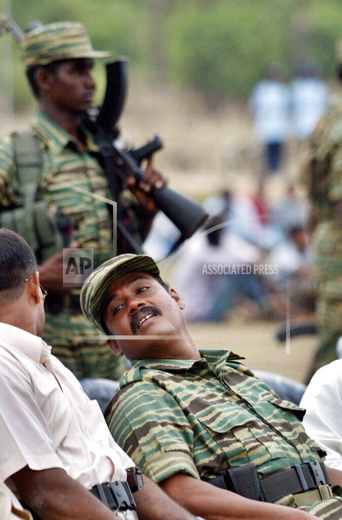 Military commander of the Tamil Tiger rebels for Batticaloa Colonel Bhanu, seated, looks on during a parade to honor rebel Black Tigers , in rebel controlled Ambalanturai village, 2005.jpg