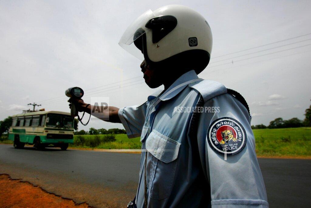 A Tamileelam traffic police constable monitors the speed of oncoming vehicle, in Kilinochchi, june 20, 2006.jpg