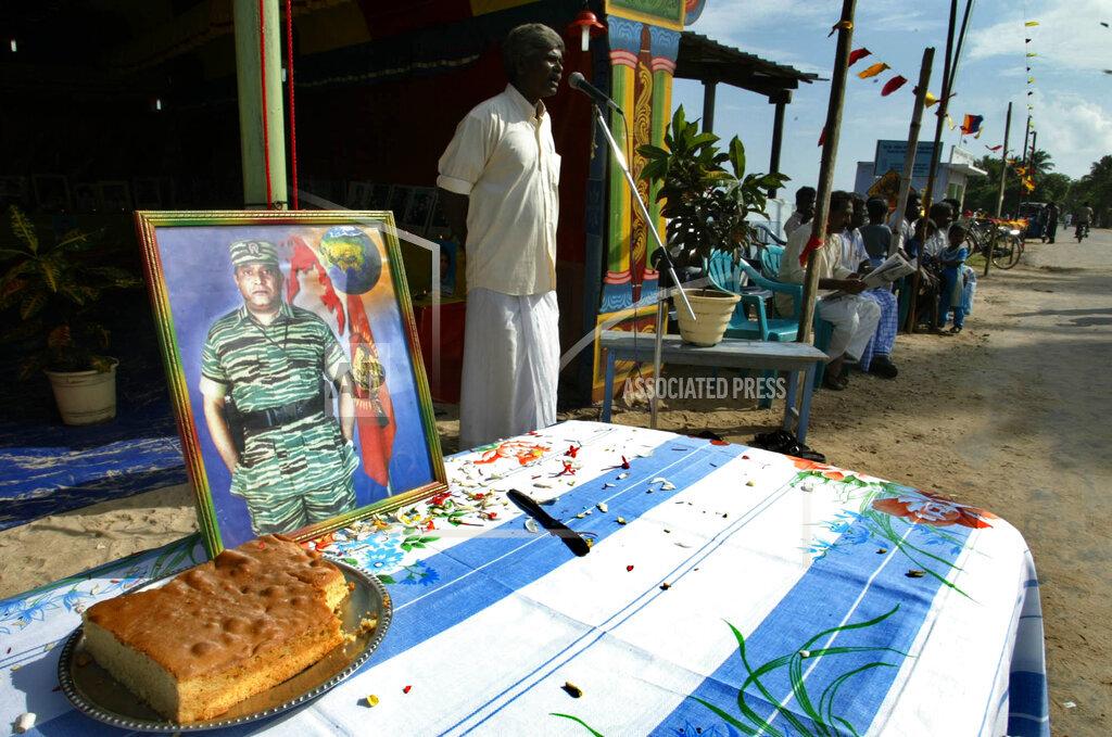 A photograph of Tamil rebel leader Velupillai Prabhakaran and a cake is seen in the foreground as supporters of Tamil rebels celebrate the 51st birthday of the rebel leader in Sakkotai, in northern Jaffna peninsula, 26, 2005.jpg