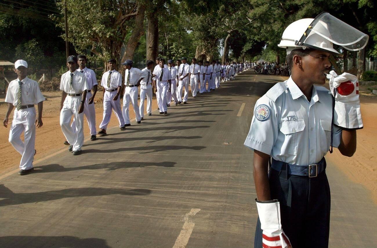 தமிழீழ காவல்துறை வீதி போக்குவரவுக் காவலர் - Tamileelam Traffic Policeman directs the traffic during the Black Tigers day on 2004 while the students of Kili. Central College passes.jpg