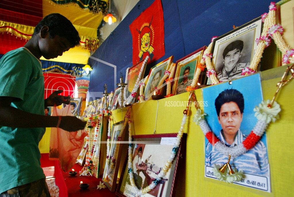A photograph of Tamil rebel leader Velupillai Prabhakaran and a cake is seen in the foreground as supporters of Tamil rebels celebrate the 51st birthday of the rebel leader in Sakkotai, in northern Jaffna peninsula, 26, 200 m5.jpg