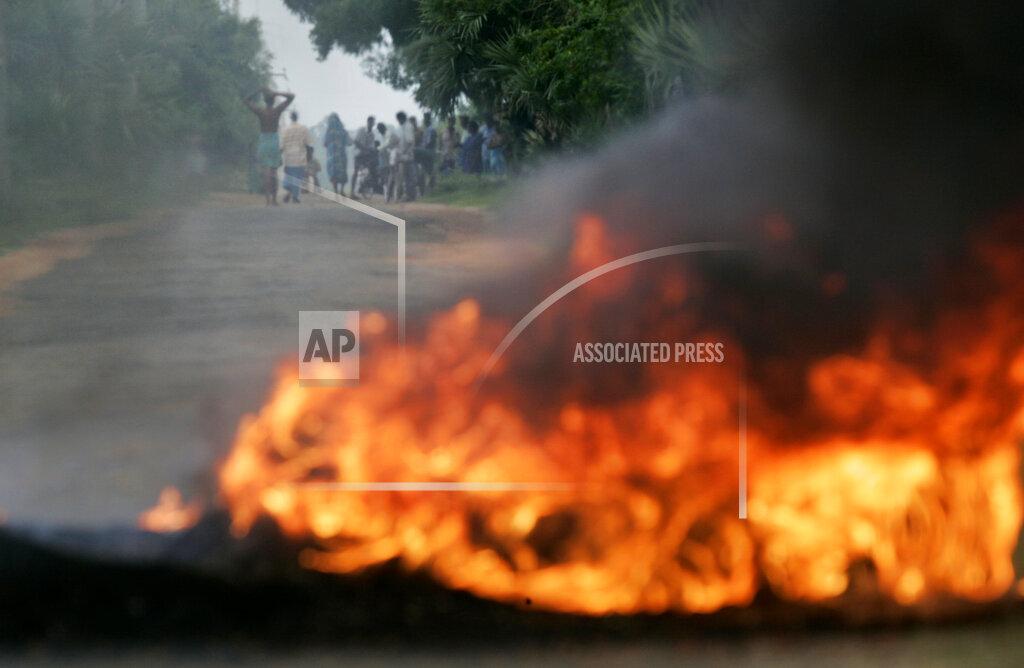 Villagers staying in the Liberation Tiger of Tamil Eelam-controlled area keep a safe distance as they watch tires burn at a roadblock in Vavunathivu, in Batticaloa district of eastern Sri Lanka, Thursday, Nov. 17, 2005..jpg