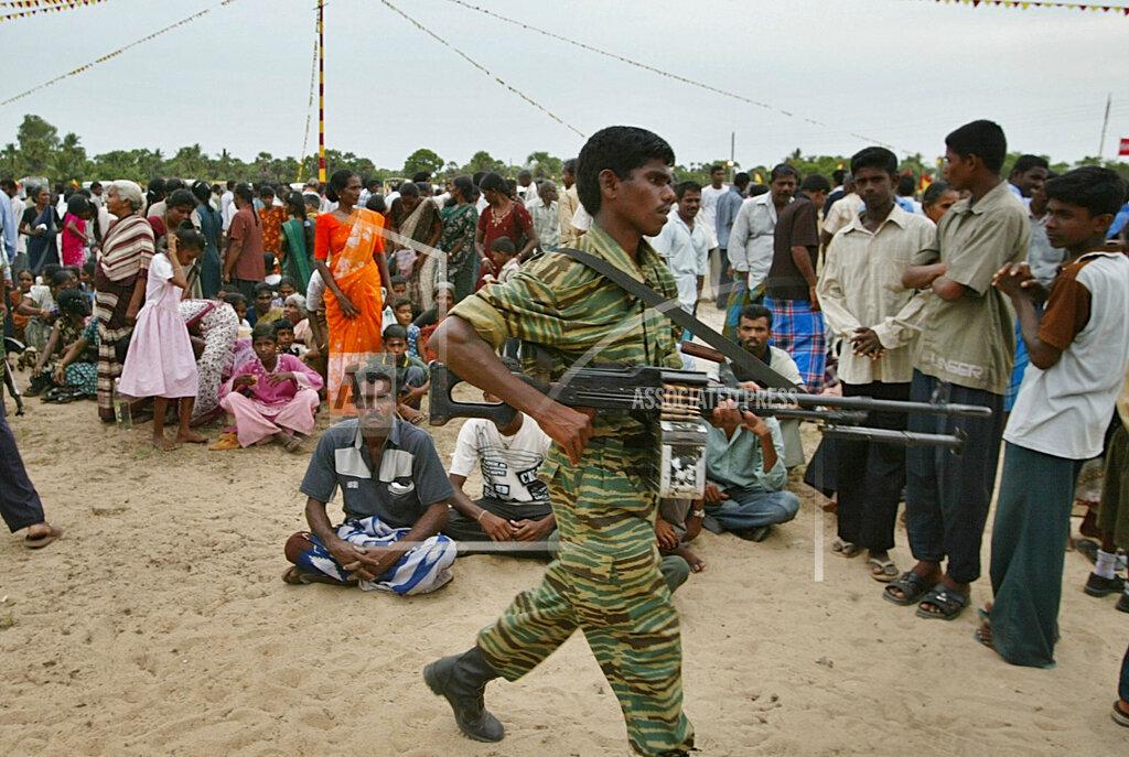 Military commander of the Tamil Tiger rebels for Batticaloa Colonel Bhanu, seated, looks on during a parade to honor rebel Black Tigers , in rebel controlled Ambalanturai village, 2005 m.jpg