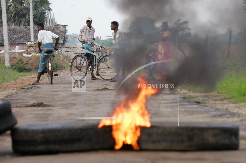 Villagers staying in the Liberation Tiger of Tamil Eelam-controlled area keep a safe distance as they watch tires burn at a roadblock in Vavunathivu, in Batticaloa district of eastern Sri Lanka, Thursday, Nov. 17, 2005...jpg
