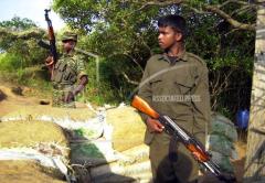 Two Tamil Tiger rebel fighters stand vigil at a road block on a road which links government controlled area and the rebel held Sampur village, close to the eastern city of Trincomalee, april 28, 2006.jpg