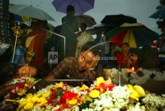 A Tamil women lies over a bed of flowers set on the grave of a loved one as Tamils remember their slain soldiers on Martyr's day, at the hero cemetery in Tamil controled Kilinochi, Sri Lanka Thursday Nov. 27, 2003.jpg