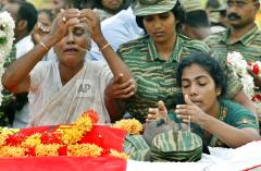 Kannankudha bati, wife Vetha, right, and his mother, in white, mourn during his funeral.jpg