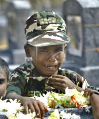 an unidentified Tamil boy cries at the grave of his father who lost his life fighting for the Liberation Tigers of Tamil Eelam, at Viswamadu cemetery, 27, 2005.jpg