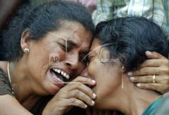 Col. Ramanan's wife Vetha, right, and his sister Bahawathi, mourn during his funeral in the rebel controlled northeastern village of Kannankudha, batti.jpg