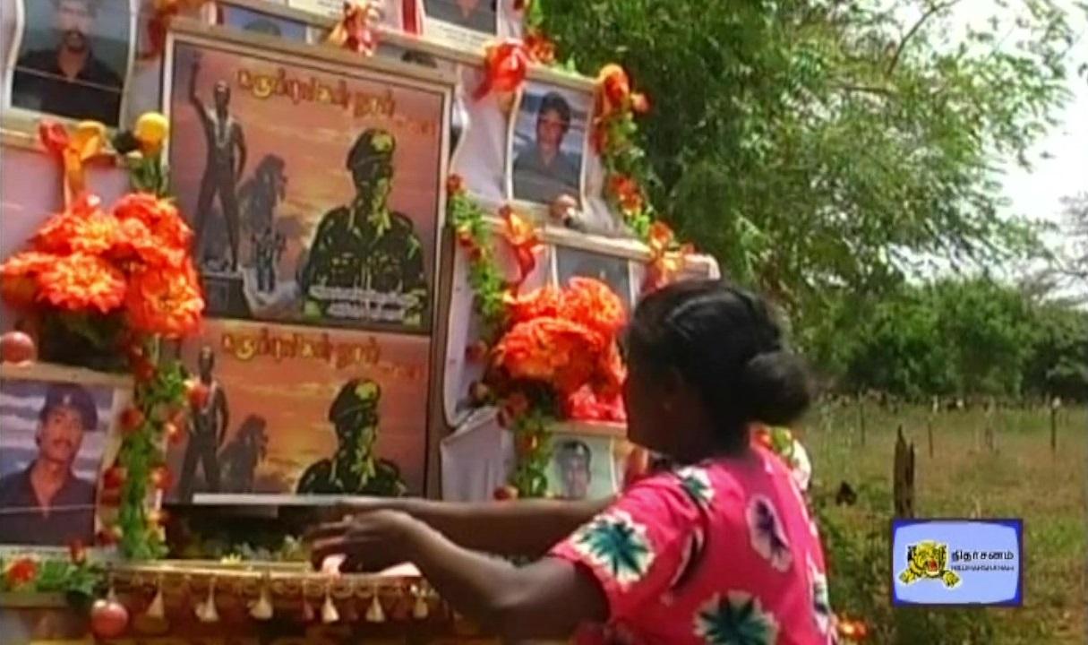 A Tamil Mother in batticalo garlanding to the fallen Black Tigers_ Photoframes carried in a vehicle at Batti..jpg