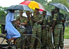 Tamil Tiger soldiers look at a passing local girl after they arrived in the main Tamil controled town of Kilinochchi, Nov. 26, 2003..jpg