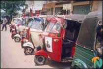 Autorickshaws in Vavuniya town with posters of the first Balck Tiger 'Captain Miller and the stage at Vavuniya Urban Council ground where the public meeting was held to mark the lack Tiger day..jpg