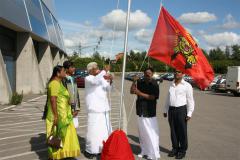 Poet Pulamaip piththan hoisting Thamizh Eezham national flag, his wife and poet Arivumathy are standing beside.jpg